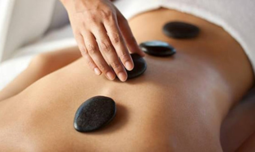 Personne recevant un massage aux peirres chaudes